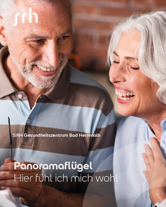 Zwei lächelnde ältere Menschen sitzen zusammen und unterhalten sich. Text: "Panoramaflügel - Hier fühl ich mich wohl."