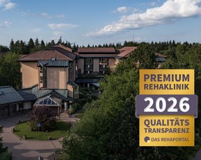 Rehaklinik mit modernen Gebäuden, umgeben von Bäumen und Grünflächen. Hinweis auf Premium-Qualität und Transparenz für 2026.
